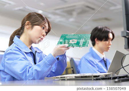 A scene of a technician performing quality checks on a printed circuit board. A scene of a technician performing quality checks on a printed circuit board. 138507049