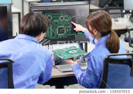 一組工程師正在審查印刷電路板設計資料。 一組工程師正在審查印刷電路板設計資料。 138507053