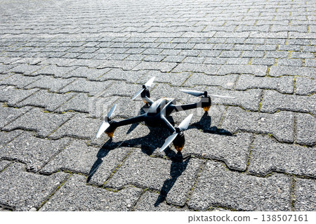 Black drone stay on the stones road near parking. Innovative modern technology. Black drone stay on the stones road near parking. Innovative modern technology. 138507161