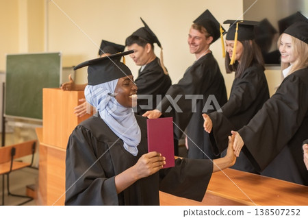 Classmates congratulate African young woman on graduation.  138507252