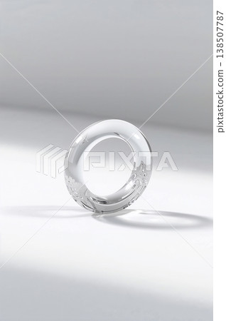 Clear ring with a design on it sits on a white background 138507787