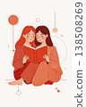 Two women are sitting on the ground reading a book 138508269