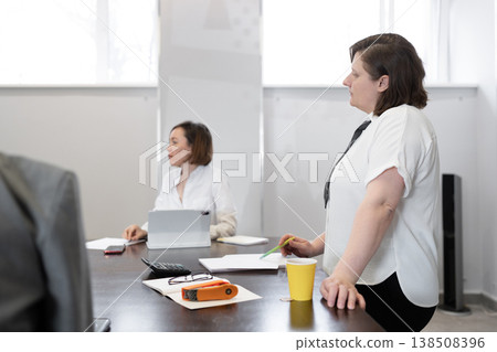 Women colleagues in white shirts attending business breakfast meeting in bright office. Breakfast, business, meeting, white shirts, office. Women colleagues in white shirts attending business breakfast meeting in bright office. Breakfast, business, meeting, white shirts, office. 138508396