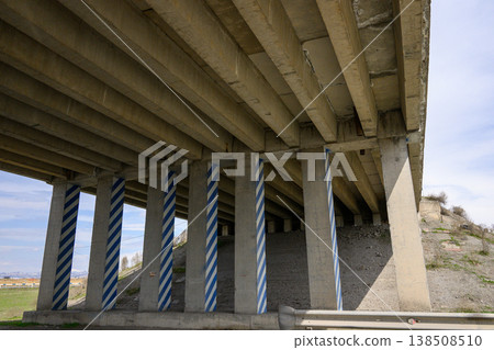 Bridge underpass with patterned support columns against a clear sky Bridge underpass with patterned support columns against a clear sky 138508510