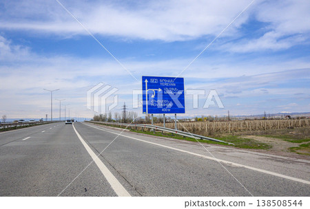 Empty highway with directional sign under clear sky 138508544