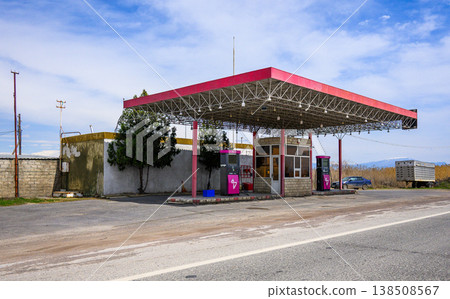 Abandoned gas station under bright sky with faded red roof 138508567