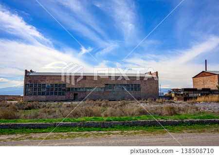 Abandoned factory building with broken windows and overgrown grass Abandoned factory building with broken windows and overgrown grass 138508710