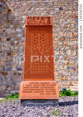 Cultural stone memorial in Armenia with detailed relief and church backdrop 138508791