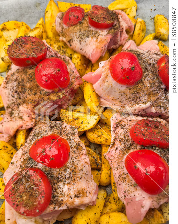Raw chicken thighs with potatoes and tomatoes ready for roasting in prague 138508847