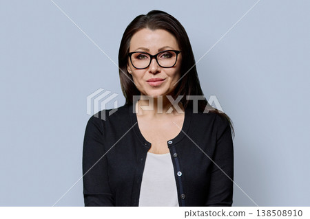 Portrait of smiling mature woman on grey background Portrait of smiling mature woman on grey background 138508910