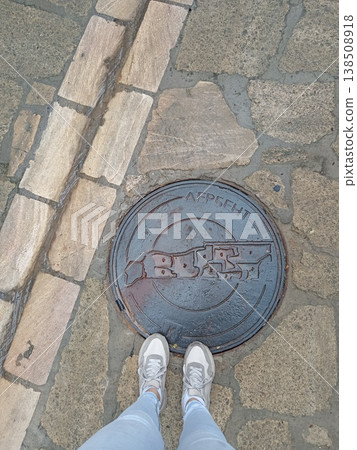 Top view of a tourist manhole with the inscription "Derbent", Dagestan, Russia. Urban detail featuring historical city name on street infrastructure Top view of a tourist manhole with the inscription "Derbent", Dagestan, Russia. Urban detail featuring historical city name on street infrastructure 138508918