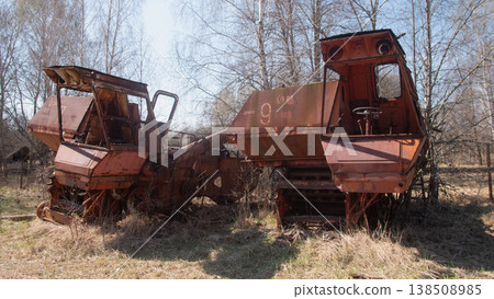 Abandoned combine harvesters in a thirty-kilometer radiation zone in Belarus. The resettlement zone after the Chernobyl nuclear power plant accident Abandoned combine harvesters in a thirty-kilometer radiation zone in Belarus. The resettlement zone after the Chernobyl nuclear power plant accident 138508985