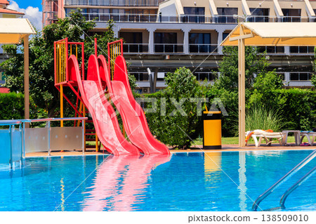 Swimming pool with water slide at the tropic summer resort Swimming pool with water slide at the tropic summer resort 138509010
