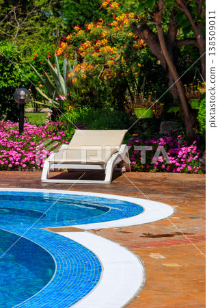 Chaise longue near a swimming pool. Concept of spa, rest, relaxation, holidays, resort Chaise longue near a swimming pool. Concept of spa, rest, relaxation, holidays, resort 138509011