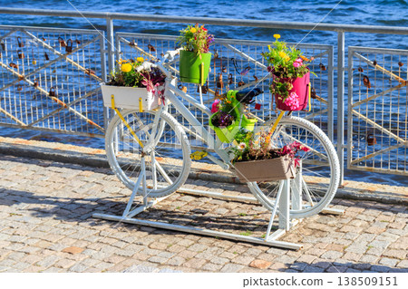 Decorative bicycle shape stand for plants and flowers on the embankment by a sea Decorative bicycle shape stand for plants and flowers on the embankment by a sea 138509151