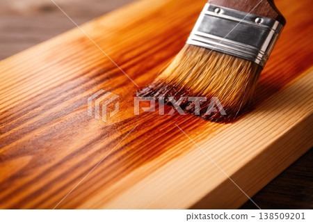 Applying wood stain with brush on natural wooden surface close up Applying wood stain with brush on natural wooden surface close up 138509201