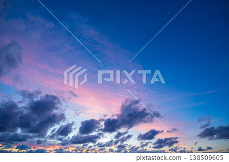 View of dramatic peaceful blue pink sky containing beautiful dark cloud formation during sunset sunrise dawn dusk creating majestic natural atmospheric background with tranquil mood 138509605
