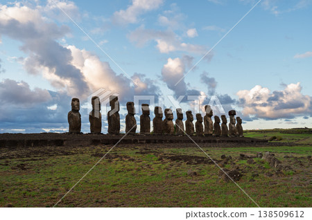 Majestic moai stand silent under dramatic cloud on easter island creating peaceful landscape across ancient rapa nui territory with mysterious stone monument history preserving old culture 138509612