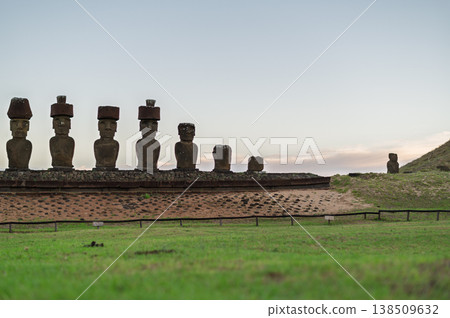 Majestic stone moai figure stands on green grass at rapa nui expressing mysterious peaceful presence across historical easter island landscape under bright morning sky Majestic stone moai figure stands on green grass at rapa nui expressing mysterious peaceful presence across historical easter island landscape under bright morning sky 138509632