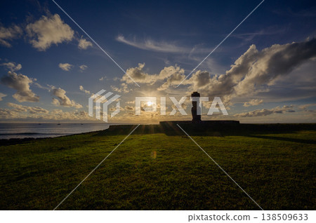 Majestic ancient moai statue stands tall on beautiful rapa nui easter island radiating peaceful energy during vibrant sunset over vast ocean creating stunning dark silhouette against cloudy sky 138509633