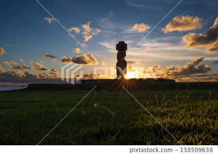 Majestic moai statue silhouette stands tranquil on grass field during peaceful sunset over ancient rapa nui on famous easter island with bright sun ray piercing dramatic sky Majestic moai statue silhouette stands tranquil on grass field during peaceful sunset over ancient rapa nui on famous easter island with bright sun ray piercing dramatic sky 138509638