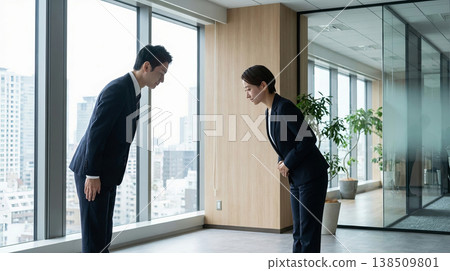 Business man and woman bowing in office as sign of respect and greeting. Business man and woman bowing in office as sign of respect and greeting. 138509801