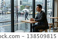 Business man drinking coffee or tea in cafe by window on rainy day 138509815