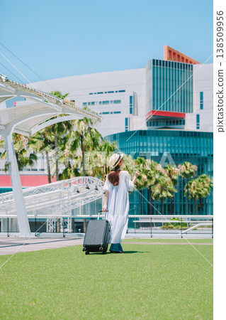 A young woman in a straw hat heading out for a resort vacation. 138509956