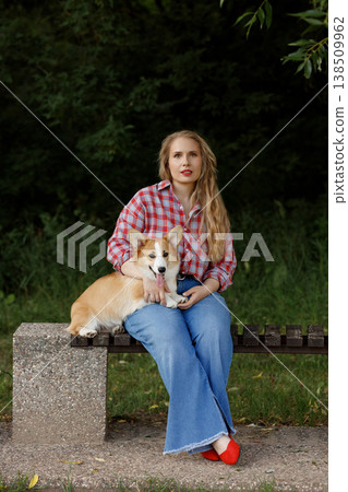 Woman With Dog. Lady Sitting With Beloved Pet. Woman Gently Holding Corgi On Her Lap Woman With Dog. Lady Sitting With Beloved Pet. Woman Gently Holding Corgi On Her Lap 138509962