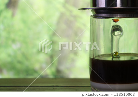 Vietnamese coffee in a glass cup with a green background 138510008