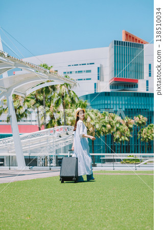 一位戴著草帽的年輕女子正準備去度假。 138510034