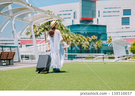 一位戴著草帽的年輕女子正準備去度假。 138510037