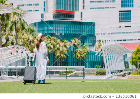 A young woman in a straw hat heading out for a resort vacation. 138510061