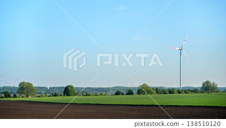 Green fields with wind power turbines, clear blue sky above Green fields with wind power turbines, clear blue sky above 138510120