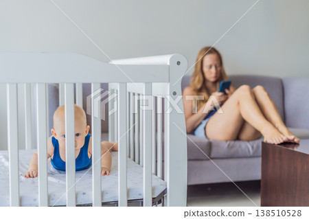 Very tired mother sitting by baby crib at home feeling exhausted. Sleep deprived mom caring for newborn at night. Parenting fatigue, motherhood stress, childcare and real family life concept Very tired mother sitting by baby crib at home feeling exhausted. Sleep deprived mom caring for newborn at night. Parenting fatigue, motherhood stress, childcare and real family life concept 138510528