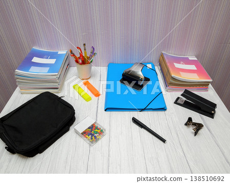 a set of office tools and colored notebooks on a light table in the room a set of office tools and colored notebooks on a light table in the room 138510692