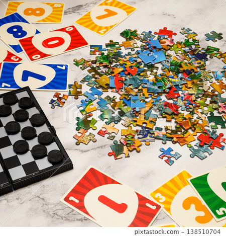 pile of colorful puzzle fragments and game elements on a light marble surface pile of colorful puzzle fragments and game elements on a light marble surface 138510704