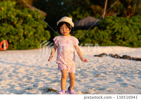 Japanese toddlers playing on the beach of a hotel in the Maldives at sunrise. Japanese toddlers playing on the beach of a hotel in the Maldives at sunrise. 138510941