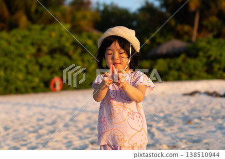 Japanese toddlers playing on the beach of a hotel in the Maldives at sunrise. 138510944