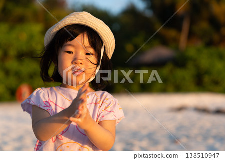 Japanese toddlers playing on the beach of a hotel in the Maldives at sunrise. 138510947