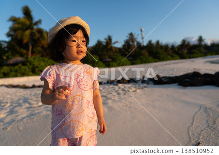 Japanese toddlers playing on the beach of a hotel in the Maldives at sunrise. Japanese toddlers playing on the beach of a hotel in the Maldives at sunrise. 138510952