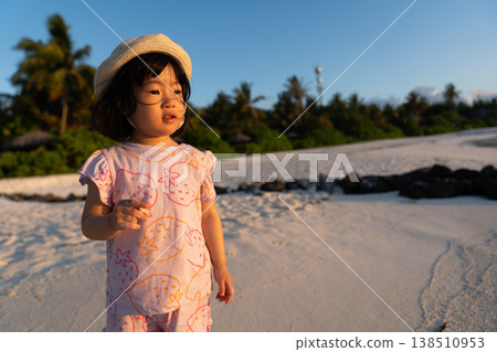 Japanese toddlers playing on the beach of a hotel in the Maldives at sunrise. 138510953