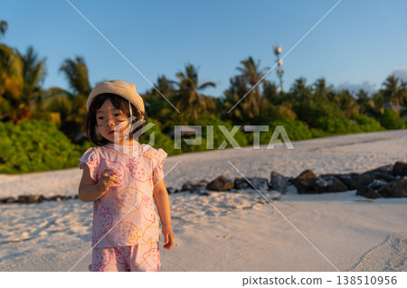 Japanese toddlers playing on the beach of a hotel in the Maldives at sunrise. 138510956