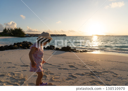 Japanese toddlers playing on the beach of a hotel in the Maldives at sunrise. Japanese toddlers playing on the beach of a hotel in the Maldives at sunrise. 138510970