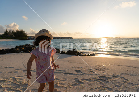 Japanese toddlers playing on the beach of a hotel in the Maldives at sunrise. 138510971