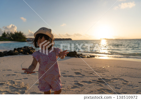 Japanese toddlers playing on the beach of a hotel in the Maldives at sunrise. 138510972