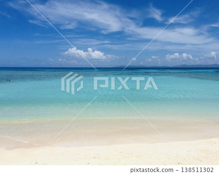 The clear, shallow waters stretching across the coral reef and the island visible in the distance. The clear, shallow waters stretching across the coral reef and the island visible in the distance. 138511302
