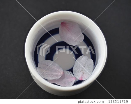 Close-up of a sake cup and cherry blossom petals Close-up of a sake cup and cherry blossom petals 138511719