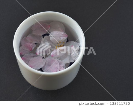 Close-up of a sake cup and cherry blossom petals Close-up of a sake cup and cherry blossom petals 138511720