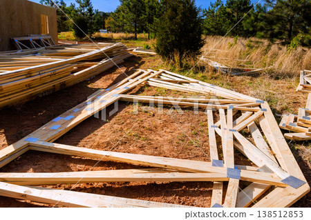 Wooden beams trusses frames are arranged on ground as construction progresses Wooden beams trusses frames are arranged on ground as construction progresses 138512853